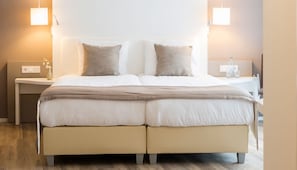 A double bed with a neutral color scheme, two bedside tables with lamps, and a wooden floor. - Family Retreat w/Scenic Views, Onsite Dining | Nature Trails & Wellness Access (Wageningen)