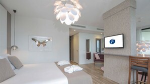 A modern hotel room with a bed, a desk, a chair, a TV, and a butterfly artwork. - Spacious Family Stay | Wellness Access & Outdoor Adventure | Valley, Forest Site (Wageningen)