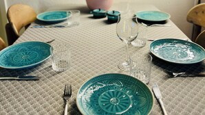 A dining table set with blue plates, clear glassware, and a bowl. - Familienurlaub nahe Europa-Park & Rulantica mit Garten, Trampolin & Balkon (Herbolzheim)