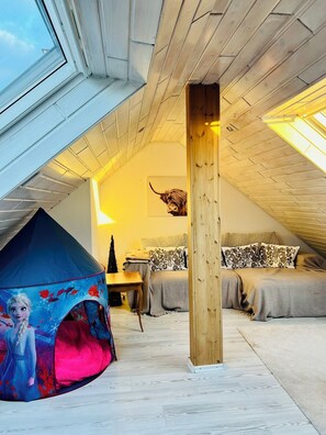 A bedroom with a sloped ceiling, a tent-like structure, a wooden beam, and a bed with patterned pillows. - Familienurlaub nahe Europa-Park & Rulantica mit Garten, Trampolin & Balkon (Herbolzheim)