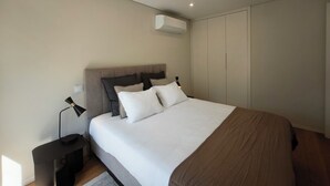 Apartamento superior, sacada, vista para a cidade | Cofres nos quartos, espaço de trabalho para notebook