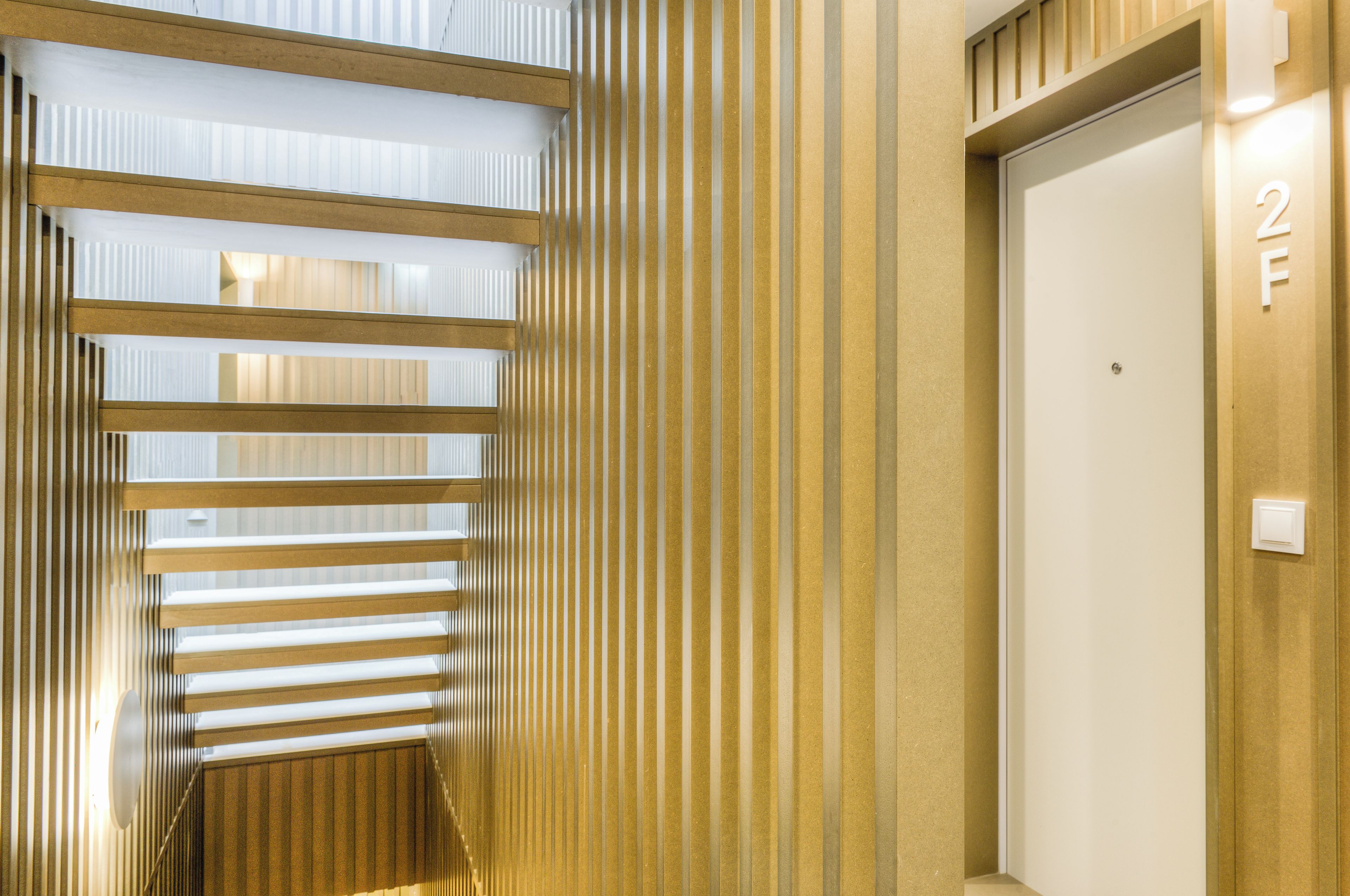 A corridor with vertical blinds and a door marked with the number 2.