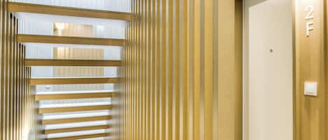 A corridor with vertical blinds and a door marked with the number 2.