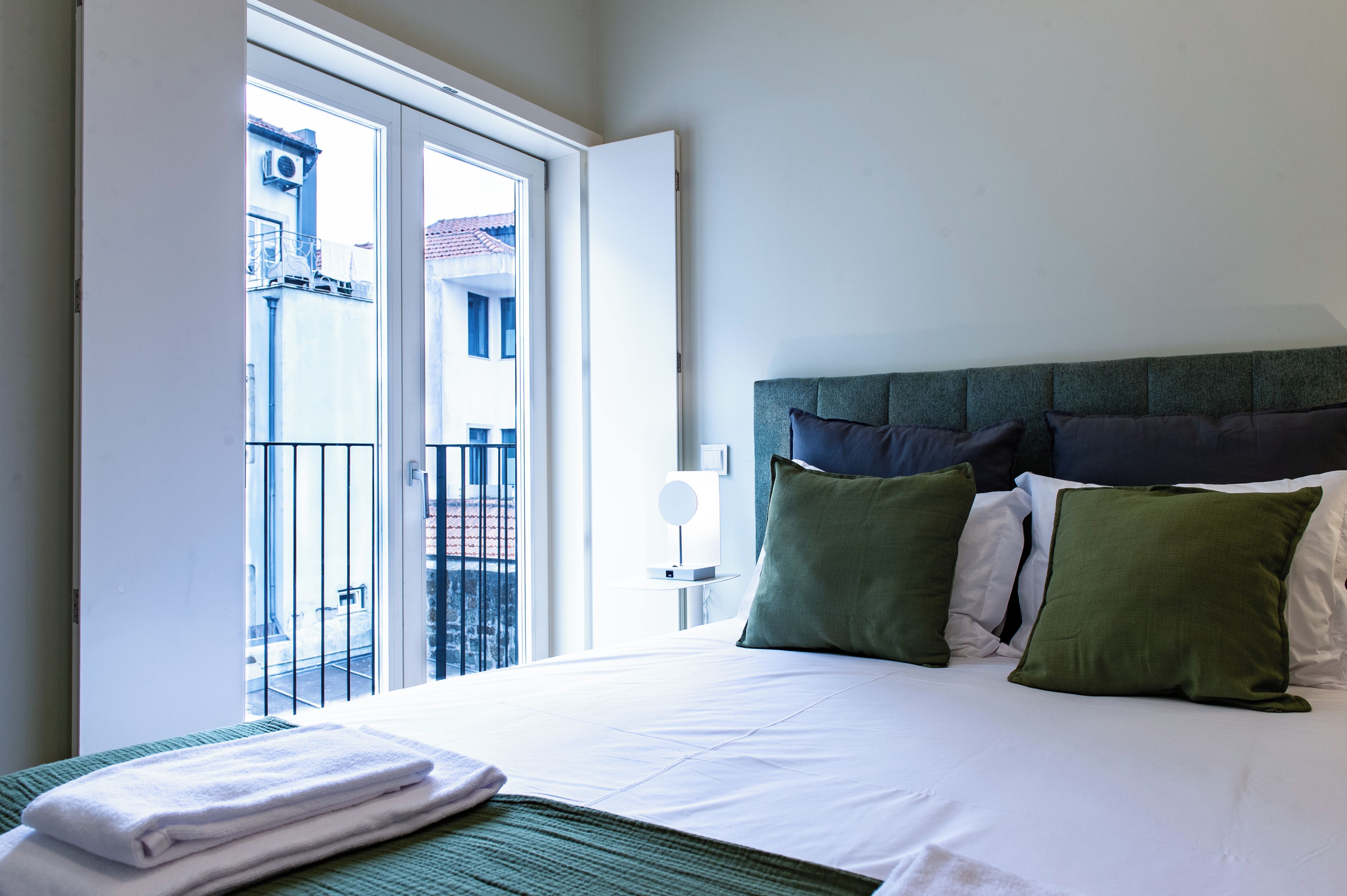 Quarto de hotel com cama, vista para o exterior e varanda.