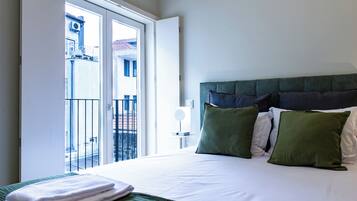 Quarto de hotel com cama, vista para o exterior e varanda.