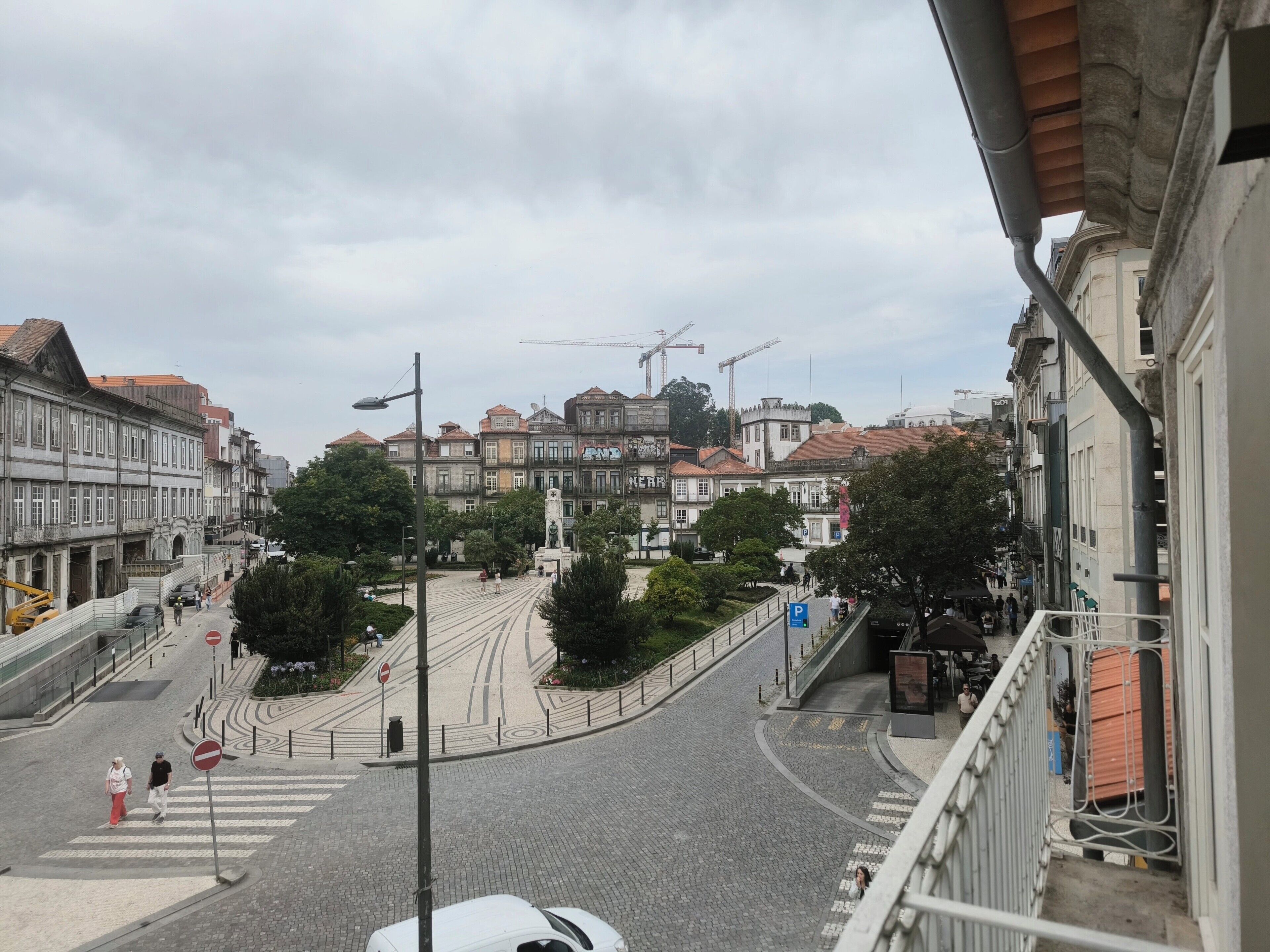 Vista de la calle con edificios, un paso de peatones y una línea de tranvía.