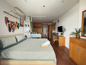 Ein modernes Schlafzimmer mit Bett, Schreibtisch, Kleiderschrank und Fernseher.