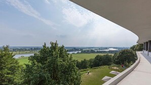 A balcony with a view of a lake and fields. - Relaxing Retreat w/Sauna, Gym & Dining | Arboretum Belmonte, De Hoge Veluwe (Wageningen)