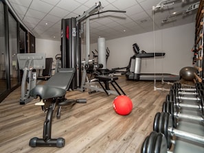 A gym with exercise equipment, a bench, a red exercise ball, and dumbbells. - Modern Haven w/Spa Access | Nature Reserves, Local Attractions | Onsite Dining (Wageningen)
