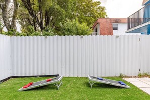 A fenced backyard with two exercise mats on artificial grass. - Cozy Retreat | Beach, Airport & Cruise Port (Fort Lauderdale)