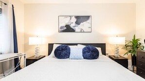 Een hotelkamer met een bed, twee bedlampen, een bureau en een kamerplant.