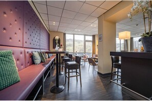 Zona de bar moderna amb distribució d'aigües, barra i vistes per grans finestres.