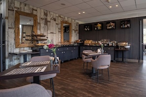 Un restaurante moderno con pared de madera, una zona de bar y una disposición de mesas.