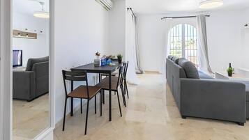 Un espace de vie moderne comprenant un coin repas, un canapé et une grande fenêtre.