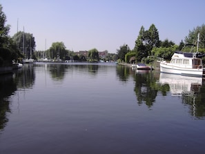 A calm river with boats docked along the shore, surrounded by trees and buildings. - Explore Huizen in Perfect Suite w/Onsite Dining Near Breathtaking Reserves (Huizen)