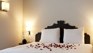 A neatly made bed with white linens and rose petals scattered across the surface. - Explore Huizen in Perfect Suite w/Onsite Dining Near Breathtaking Reserves (Huizen)