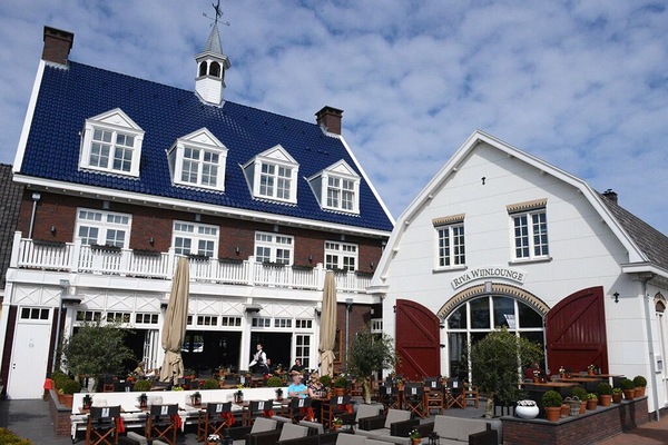 Sip and savor on the bustling terrace beneath blue skies.