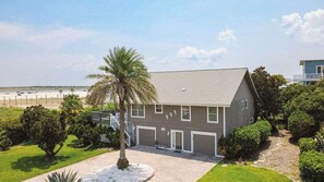 A two-story residential building with a garage, a palm tree, and a well-maintained lawn. - Palencia by the Sea - Ocean & Lighthouse Views (St. Augustine)
