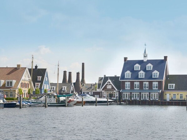 Eine Uferlandschaft mit traditioneller Architektur und vertäuten Booten.