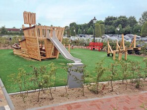 A playground with a wooden slide and climbing structures.