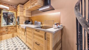 A modern kitchen with wooden cabinets, a stainless steel sink, and a black range hood. - Keepers Lodge - Sleeps 4 (Nottingham)