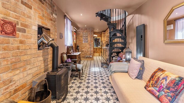 A cozy interior with a brick wall, a spiral staircase, a sofa, and a tiled floor. - Keepers Lodge - Sleeps 4 (Nottingham)