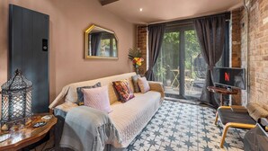 A cozy room with a sofa, a TV, and a decorative lantern. - Keepers Lodge - Sleeps 4 (Nottingham)