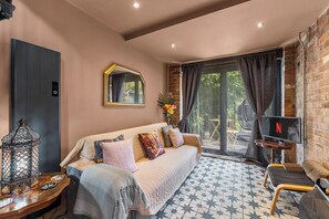 A cozy room with a sofa, a TV, and a decorative lantern. - Keepers Lodge - Sleeps 4 (Nottingham)