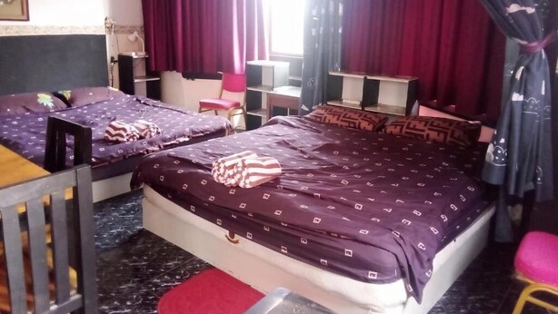 A room with two beds, a desk, a chair, and a small table. - Room-charming Family Room in South Patt (Pattaya)