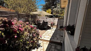 A stone pathway leading to a patio area with outdoor furniture and a covered seating area.