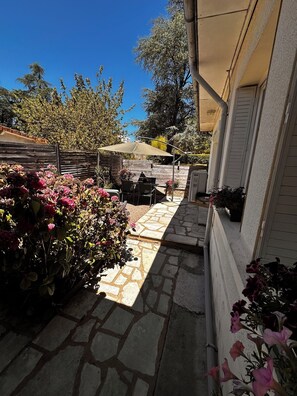 A stone pathway leading to a patio area with outdoor furniture and a covered seating area.