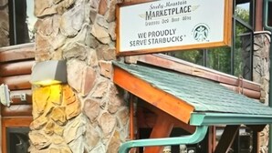 Un muro di pietra con un cartello che indica un Starbucks.