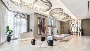A spacious lobby with a reception desk, modern lighting fixtures, and a large window. - 3-bedroom At Hyde Beach House Hollywood With Gym, Beach & Pool Service (Hollywood)