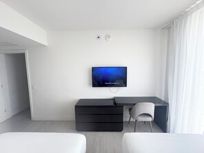 A modern bedroom with a flat-screen TV mounted on the wall, a desk with a chair, and a bed. - 3-bedroom At Hyde Beach House Hollywood With Gym, Beach & Pool Service (Hollywood)