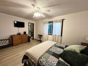 A bedroom with a bed, dresser, television, and a ceiling fan. - The Woodlands Charity  -Large Private Room & bath in Tallmadge (Tallmadge)