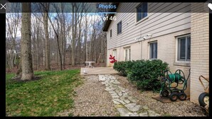 A house with a stone pathway leading to a front door, a lawn, and a wooded area. - The Woodlands Charity  -Large Private Room & bath in Tallmadge (Tallmadge)