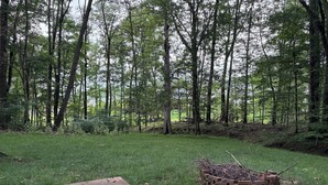A grassy area with a brick fire pit and a concrete structure. - The Woodlands Charity  -Large Private Room & bath in Tallmadge (Tallmadge)