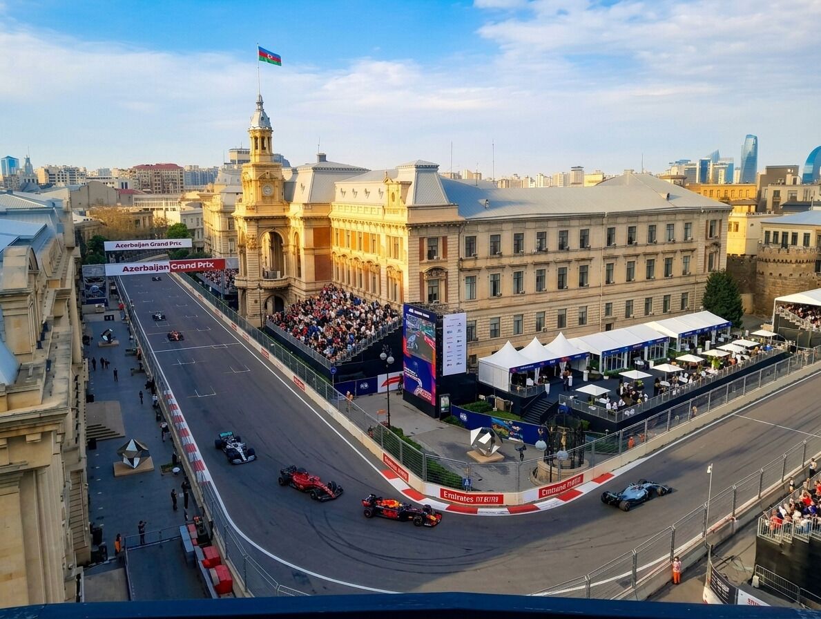 Un edificio imponente con una torre de reloj, una pista de carreras y una multitud de espectadores.