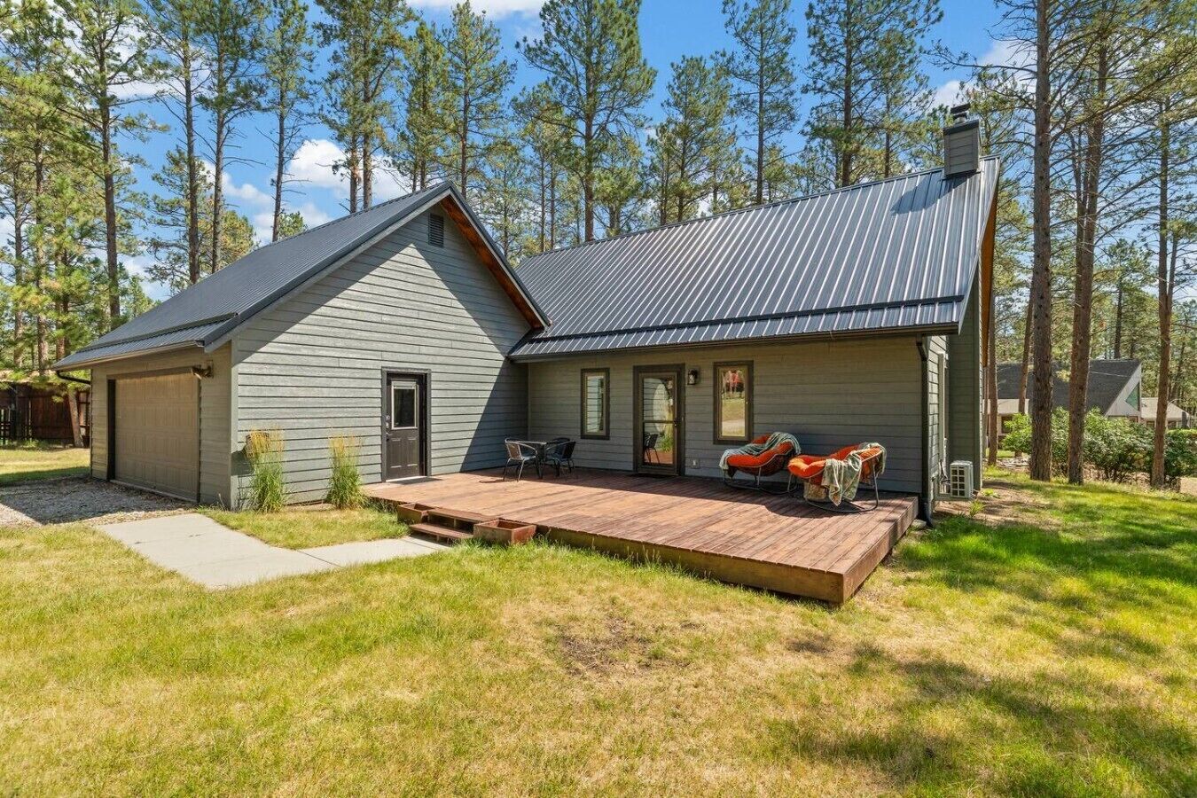 A two-story house with a covered porch and a deck.