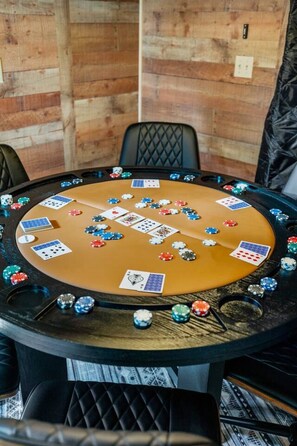 A poker table with chips and cards, surrounded by chairs. - Forest Road Haven: 3 King BR-GameRoom-HotTub-Sauna (Rapid City)