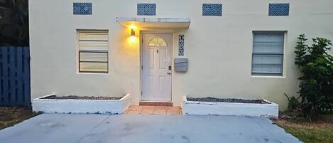 A house with a white door, a small porch, and a mailbox.