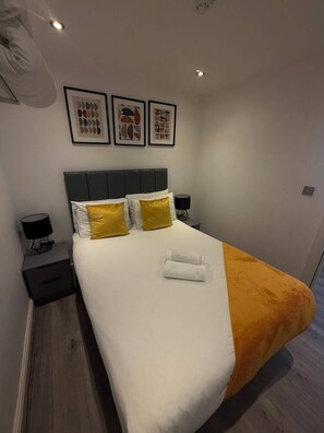 A modern hotel room with a large bed, two bedside tables, and a headboard. - Modern City Centre 1 Bedroom Apartment (Liverpool)