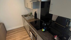 Cocina compacta con horno integrado, estufa y pileta.