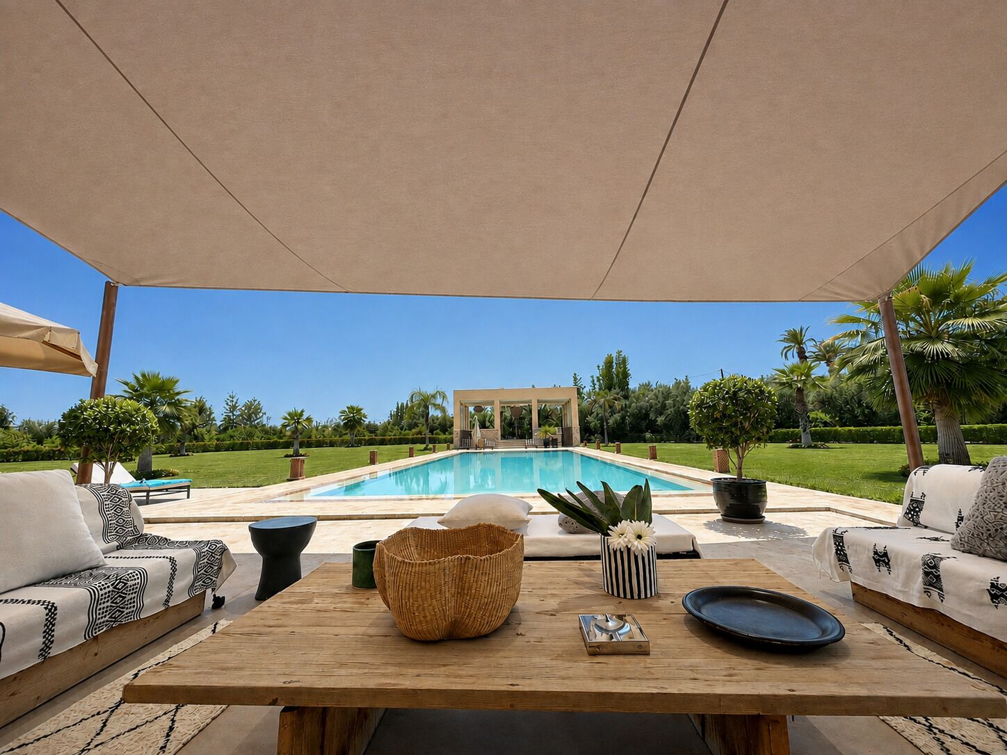 An outdoor seating area with a pool in the background.