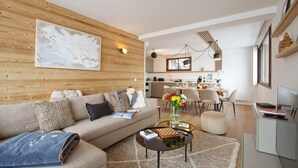 Ein modernes Wohnzimmer mit einer Couch, einem Couchtisch und einem Essbereich mit Stühlen.