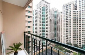 A balcony with a potted plant, overlooking high-rise residential buildings. - Home Away from Home at Shine Residences (Pasig)