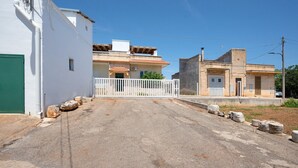 A street with buildings, a white gate, and a clear sky. - Apartment 'Alle Colonne Bianche Rooms' with Balcony, Wi-Fi and Air Conditioning (Conversano)