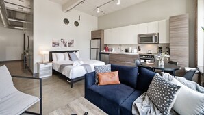 A modern apartment with a bedroom, living area, and kitchen. - Stylish Downtown Stay | Pool, Gym, Valet Parking (Dallas)