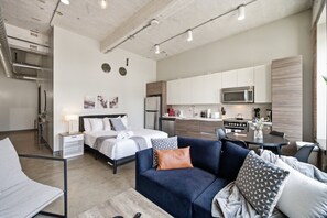 Eine moderne Wohnung mit Schlafzimmer, Wohnbereich und Küche.