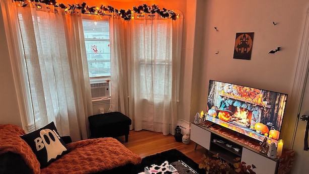 Ein gemütliches Wohnzimmer mit einer Couch, einem Fernseher und Halloween-Dekorationen.
